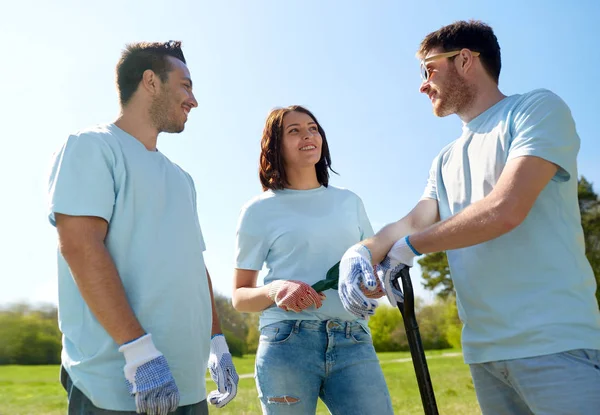 Grupo de voluntários com ferramentas de jardim no parque — Fotografia de Stock