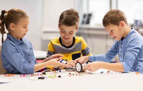 Gelukkige kinderen bouwen robots op robotica school — Stockfoto