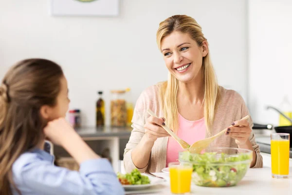 Familia feliz comer ensalada en casa cocina —  Fotos de Stock
