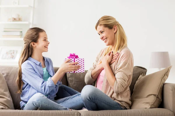 Menina dando presente de aniversário para a mãe em casa — Fotografia de Stock