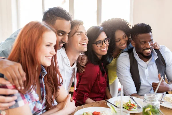 Amigos felizes comendo no restaurante — Fotografia de Stock