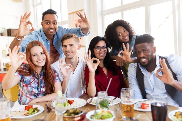 Amigos felices mostrando signo de mano ok en el restaurante — Foto de Stock