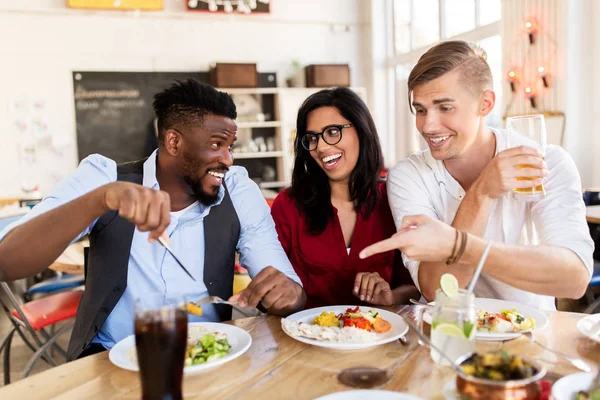 Amici felici mangiare e divertirsi al ristorante — Foto Stock