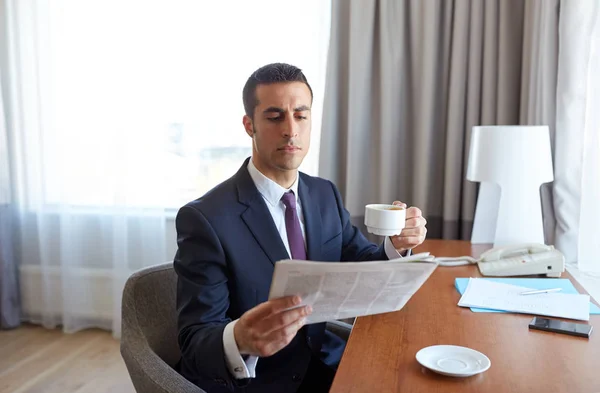 Бизнесмен читает газеты и пьет кофе — стоковое фото