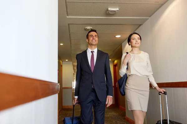 Equipo de negocios con bolsas de viaje en el pasillo del hotel — Foto de Stock