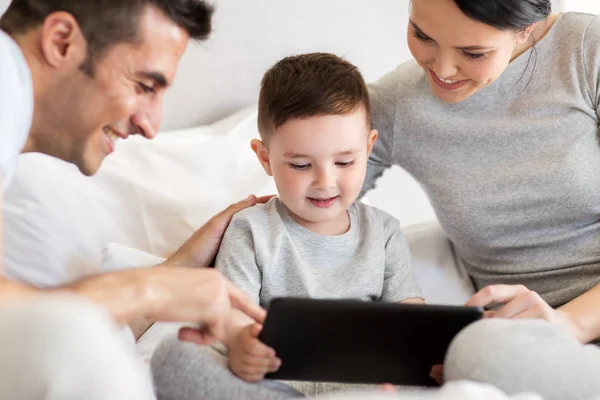 Lycklig familj med TabletPC i sängen hemma — Stockfoto