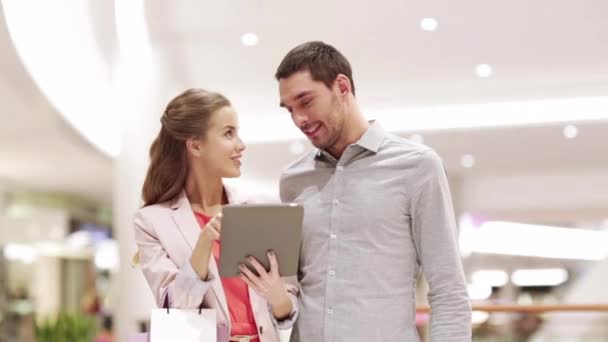 Casal com tablet pc e sacos de compras no shopping — Vídeo de Stock