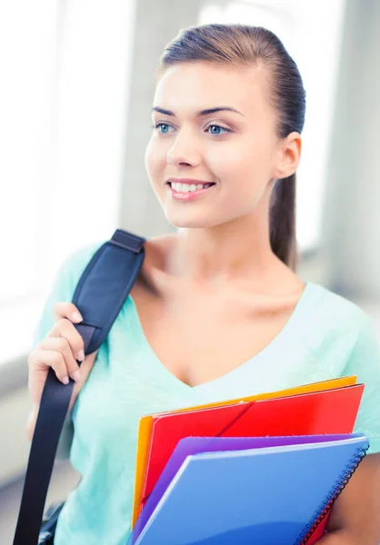 Menina estudante com saco escolar e pastas de cores — Fotografia de Stock