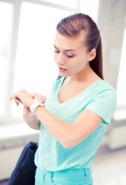 Zdziwiony student dziewczynka, patrząc na zegarek — Zdjęcie stockowe
