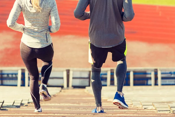 Close up of couple running downstairs on stadium — Stock Photo, Image