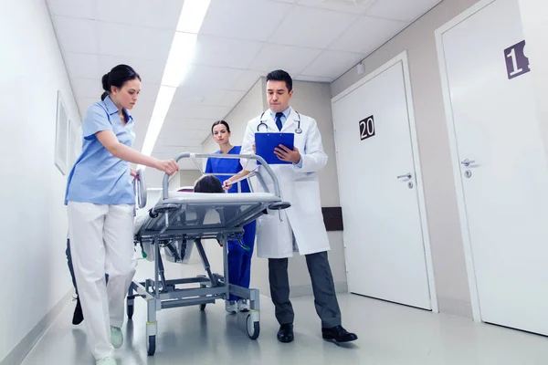 Medics with woman on hospital gurney at emergency — Stock Photo, Image