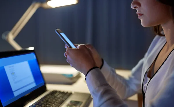 Geschäftsfrau mit Smartphone im Nachtbüro — Stockfoto