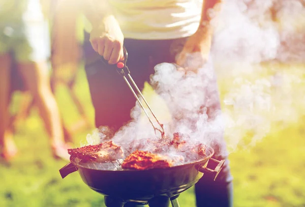 Man koken van vlees op barbecue grill op zomer feest — Stockfoto