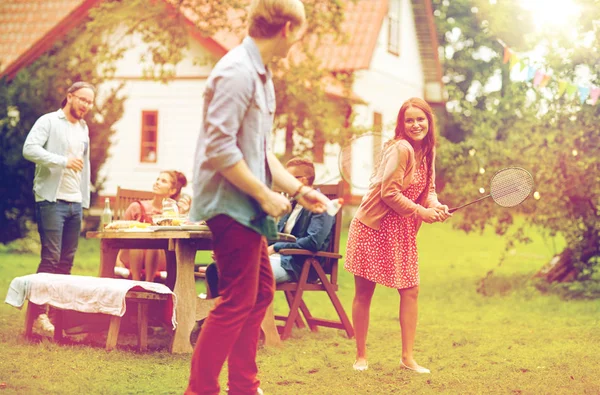 Amis heureux jouant au badminton au jardin d'été — Photo