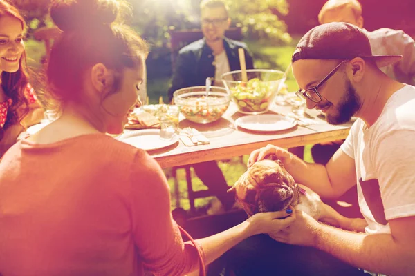 Ευτυχείς φίλοι έχοντας το γεύμα στο καλοκαιρινό πάρτι στον κήπο — Φωτογραφία Αρχείου