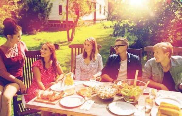 Happy vrienden hebben van diner bij zomer tuinfeest — Stockfoto