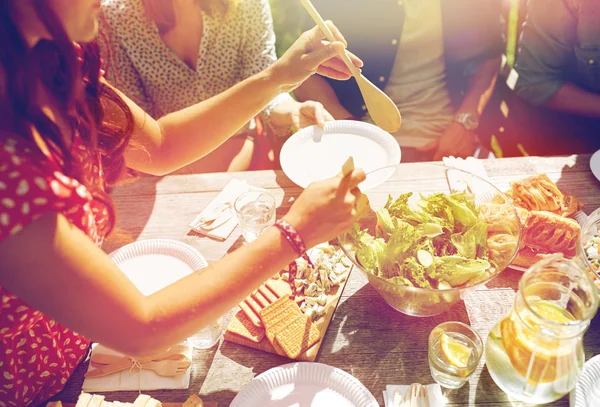 Счастливые друзья, ужинающие на летней вечеринке — стоковое фото