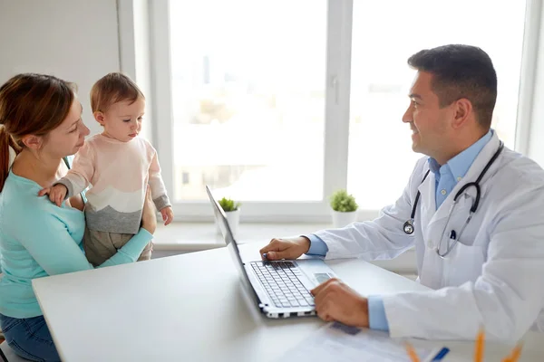 Kvinna med baby och läkare med laptop på klinik — Stockfoto