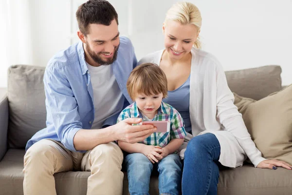 Gelukkig gezin met smartphone thuis — Stockfoto