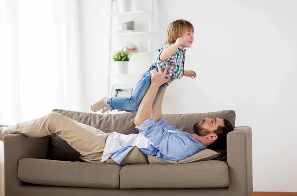 Feliz jovem pai brincando com o pequeno filho em casa — Fotografia de Stock