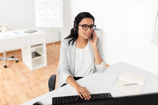 Mujer de negocios con auriculares y computadora en la oficina — Foto de Stock