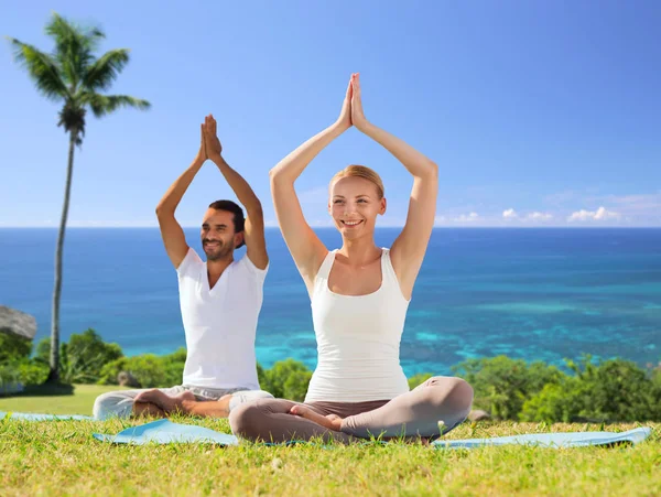 Couple doing yoga in lotus pose outdoors — Stock Photo, Image