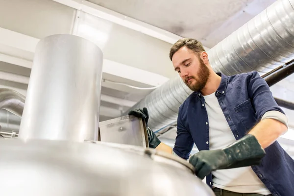 Hombre que trabaja en una fábrica de cerveza artesanal o una fábrica de cerveza — Foto de Stock