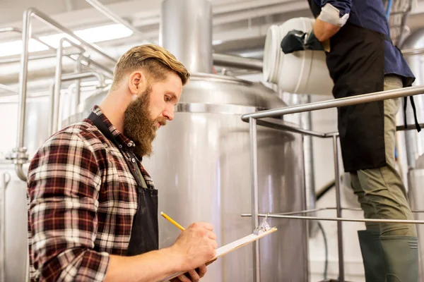 Hombres que trabajan en una fábrica de cerveza artesanal o una fábrica de cerveza — Foto de Stock