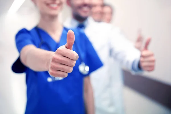 Закрытие врачей в больнице, показывающих большие пальцы — стоковое фото
