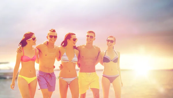 Lachende vrienden in zonnebril op zomer strand — Stockfoto