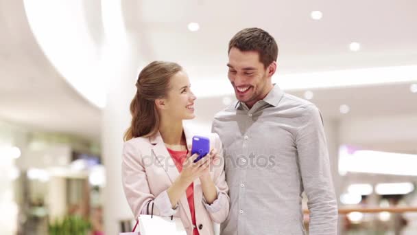 Счастливая пара со смартфоном, делающая селфи в торговом центре — стоковое видео