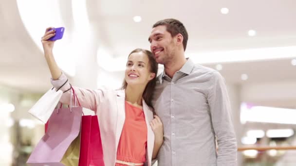 Happy couple with smartphone taking selfie in mall — Stock Video