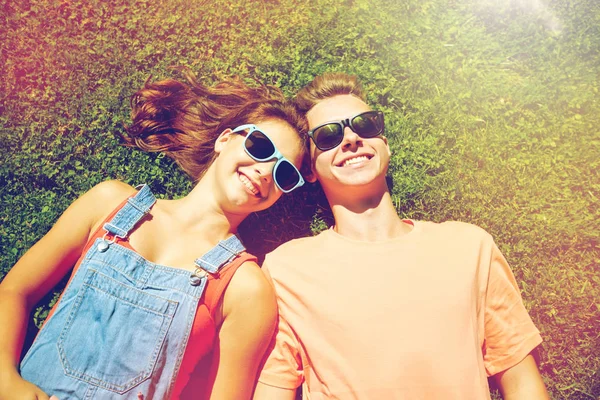 Feliz pareja adolescente acostada en la hierba en verano — Foto de Stock