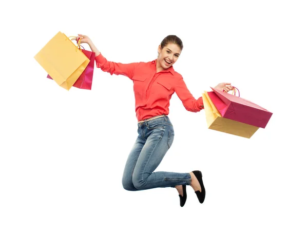 Sourire jeune femme avec des sacs à provisions sautant — Photo