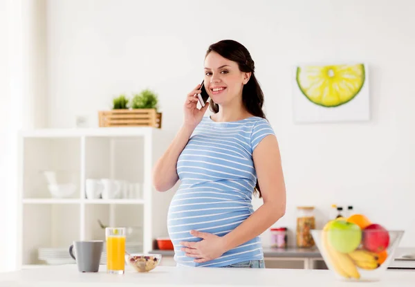 Glückliche Schwangere telefoniert zu Hause mit dem Smartphone — Stockfoto