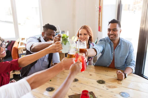 Amis cliquetis verres avec boissons au restaurant — Photo