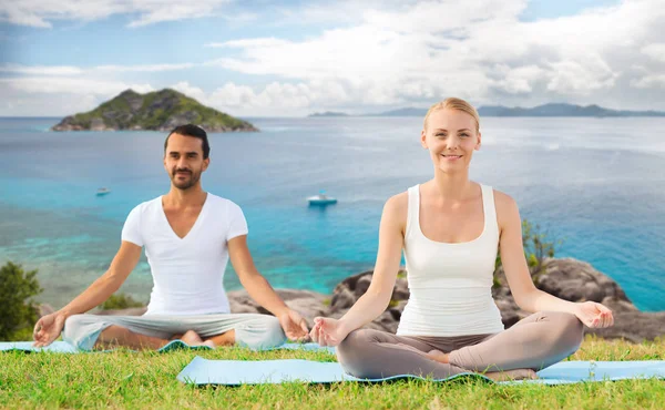 Feliz pareja haciendo ejercicios de yoga al aire libre —  Fotos de Stock