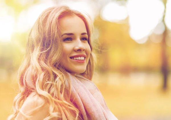 Schöne glückliche junge Frau lächelt im herbstlichen Park Stockbild