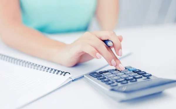 Geschäftsfrau arbeitet mit Taschenrechner im Büro — Stockfoto