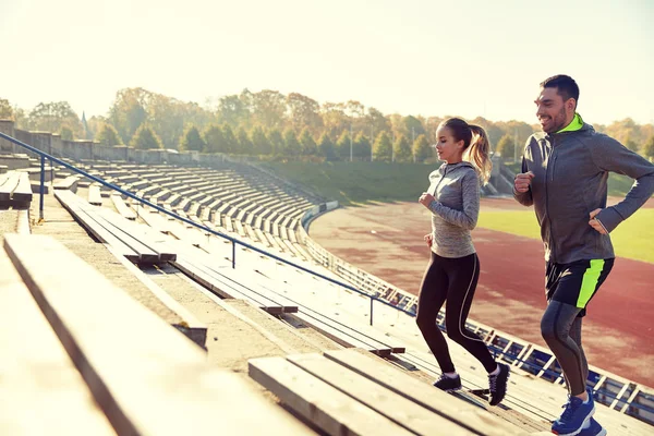 Happy couple running upstairs on stadium — Stock Photo, Image