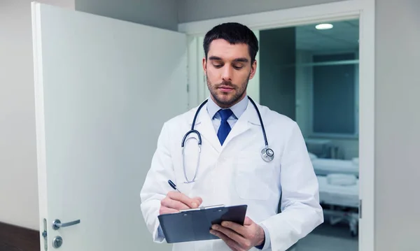 Médico escrevendo para área de transferência no hospital — Fotografia de Stock