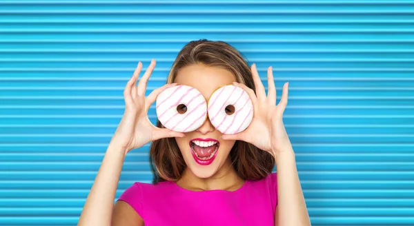 Mulher feliz ou menina adolescente olhando através de donuts — Fotografia de Stock