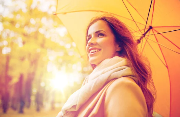 Happy woman with umbrella walking in autumn park — Stock Photo, Image