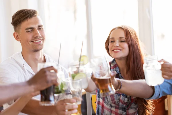 Vrienden rammelende bril met drankjes bij restaurant — Stockfoto