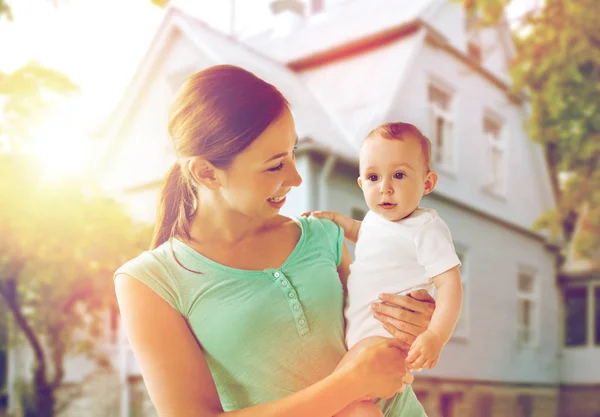 Glad ung mamma med bebis över helgdagar lampor — Stockfoto