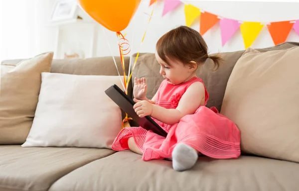 Bebé niña con tableta pc en fiesta de cumpleaños en casa —  Fotos de Stock