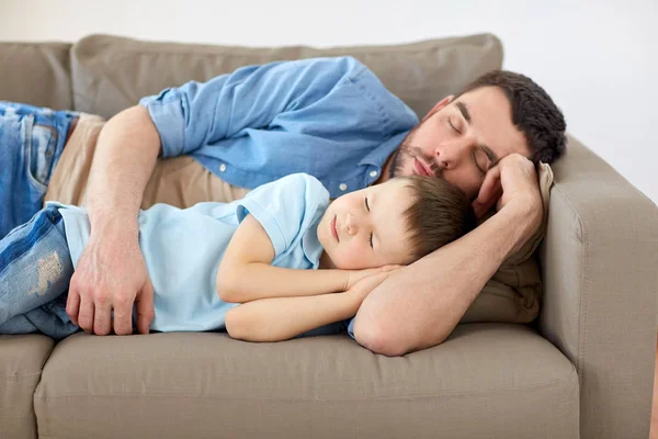 Feliz padre e hijo durmiendo en el sofá en casa —  Fotos de Stock