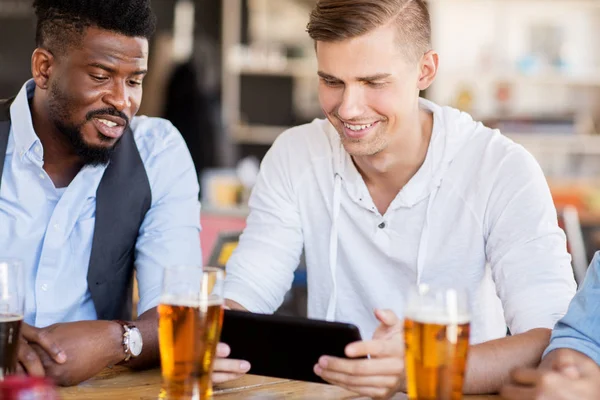 Amici maschi con tablet pc bere birra al bar — Foto Stock