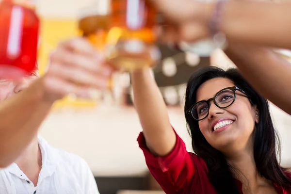 Vänner som spottar glasögon med drycker på restaurang — Stockfoto