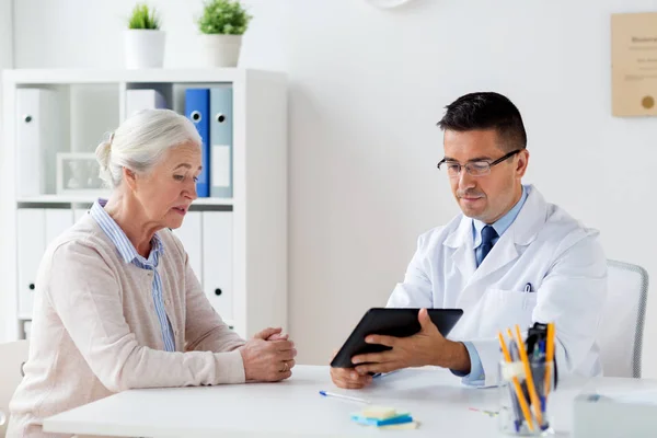 Äldre kvinna och läkare med tablettdator på sjukhus — Stockfoto